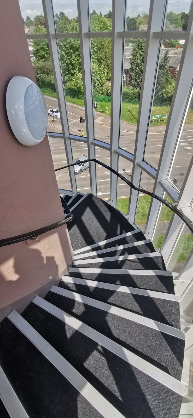 View down the building's glazed stairwell to the road several storeys below
