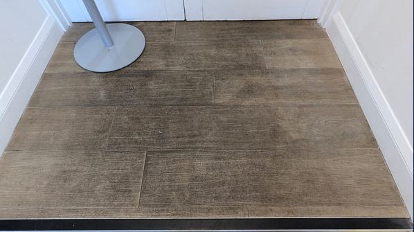 Entrance floor before the deep clean, with ingrained grey-black discolouration